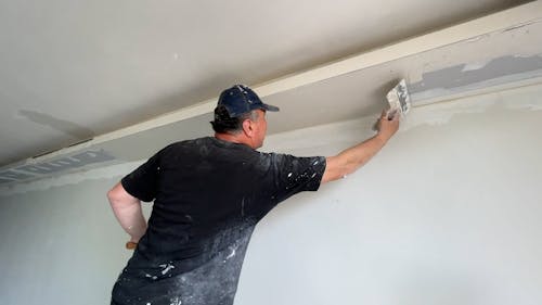 A Man Renovating a Ceiling