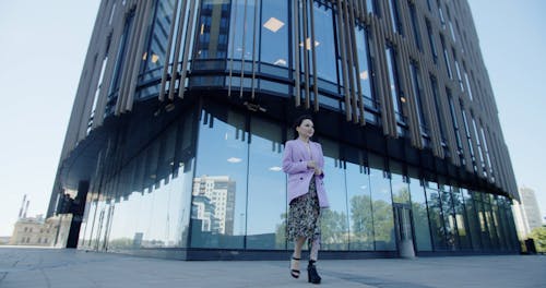 Low Angle Footage of a Fashionable Woman Walking Outside a Building
