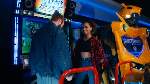 A Young Couple Playing a Dancing Arcade Game 