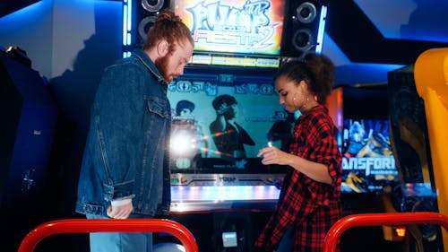 A Man and a Woman Playing a Dancing Arcade Game 