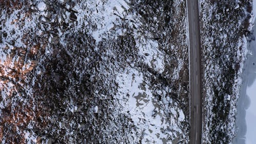 Aerial Footage of a Road Beside a Snowy Moutain