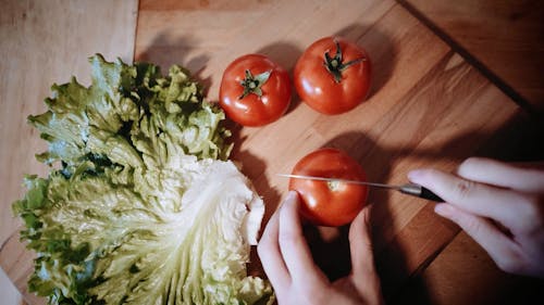 A Person Slicing a Tomato