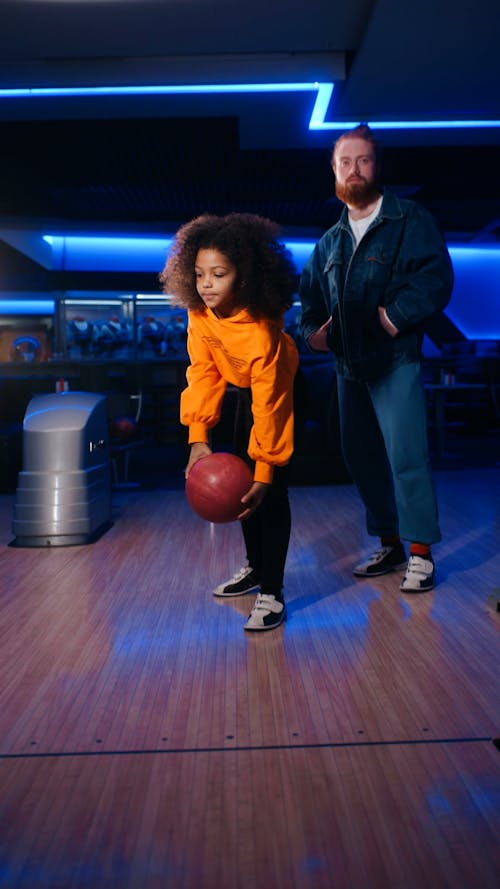 Girl and man bowling and cheering