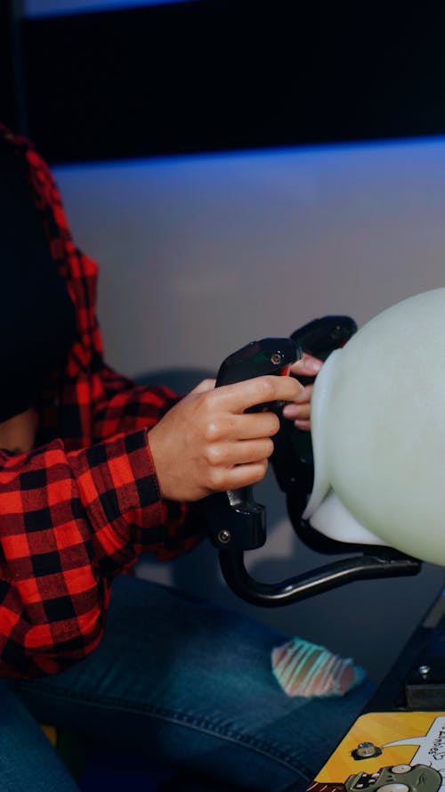 Close-up view of woman holding arcade controller