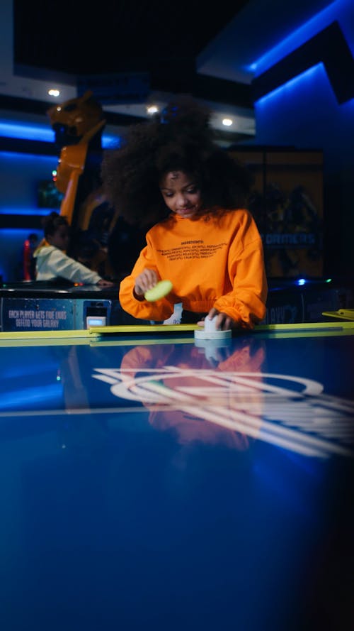 Curly hair girl playing air hockey