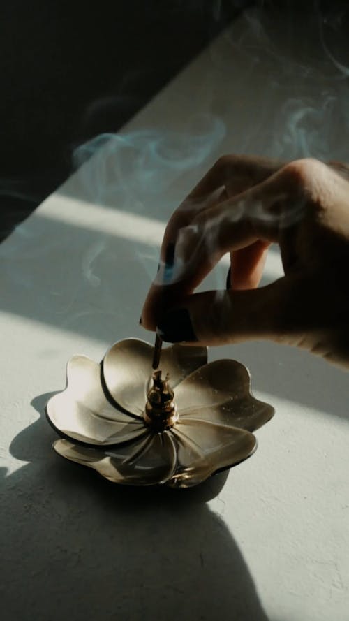 Hand of woman placing incense stick
