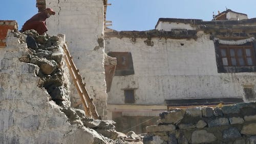 Man Throwing Stones While Demolishing Building