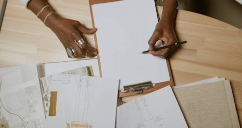 Person Drawing on a Paper with a Pencil