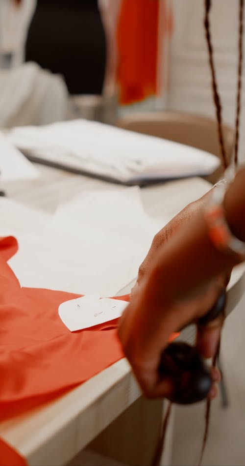 A Person Cutting a Red Fabric