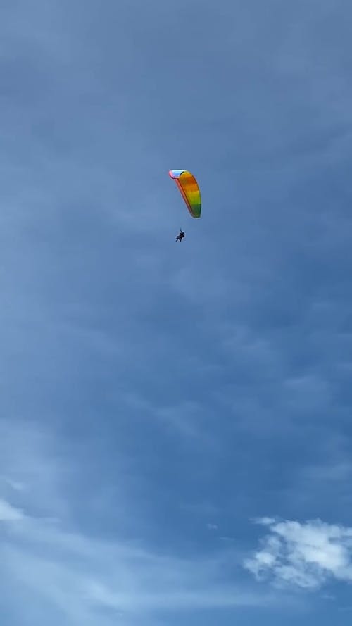 Person Flying with Paraglide in Rainbow Colors