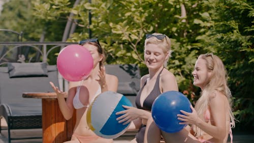 Girls Wearing Bikini while Throwing a Ball on the Pool