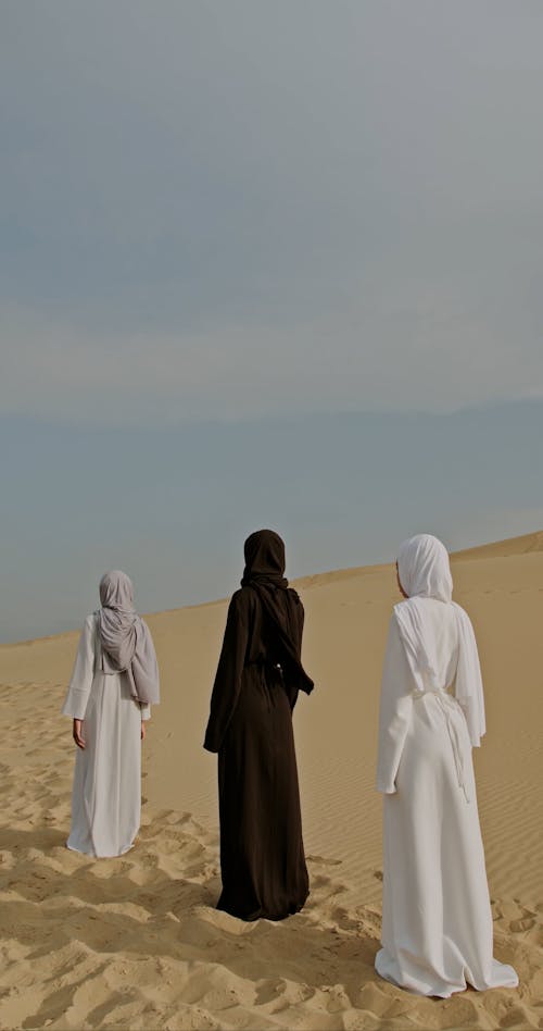 Three Women Standing on Desert and Turning at Camera