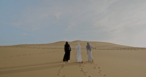 Three Women Walking over Desert