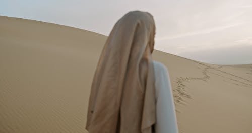 Woman Standing on Desert and Turning Back