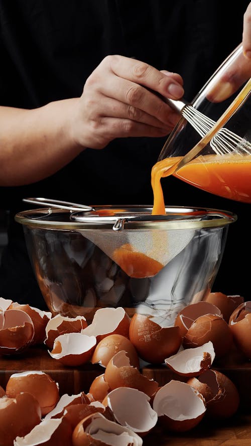 Cook Pouring Eggs Through Filter