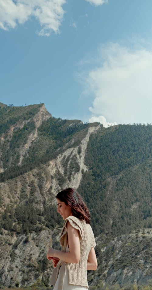 Young Woman Walking in Scenery with Mountains
