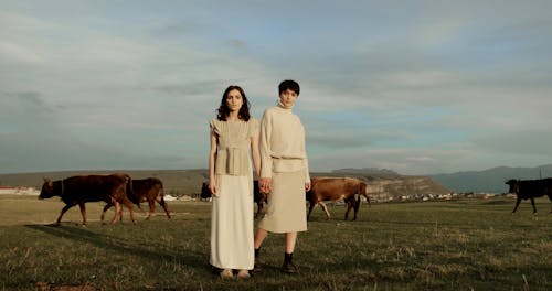 Women Holding Hands while in the Pasture