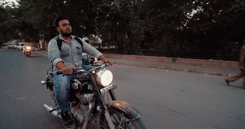 Man Riding Motorcycle Along Street