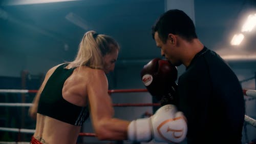 A Man and Woman Punching Each Other Inside the Boxing Ring