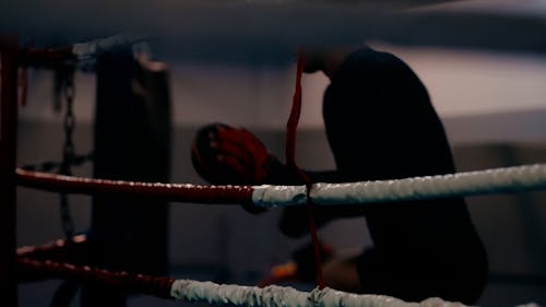 A Trainer Getting in a Boxing Ring 