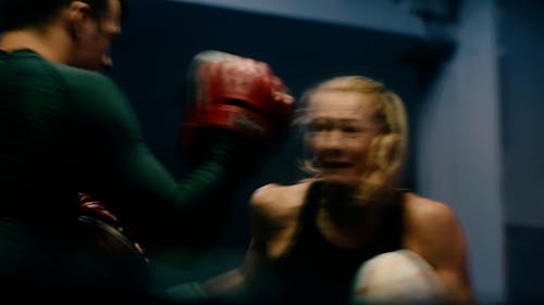 A Female Boxer Training with her Coach