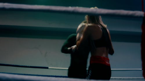 A Woman and a Man Training in a Boxing Ring