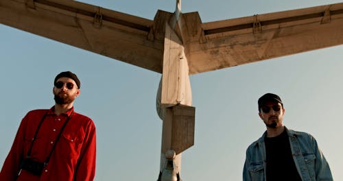 Men Standing by an Abandoned Airplane on the Shore