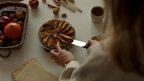 A Person Putting a Sliced of Pastry on a Plate