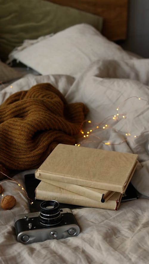 A Person Putting a Cup of Tea on the Stack of Books