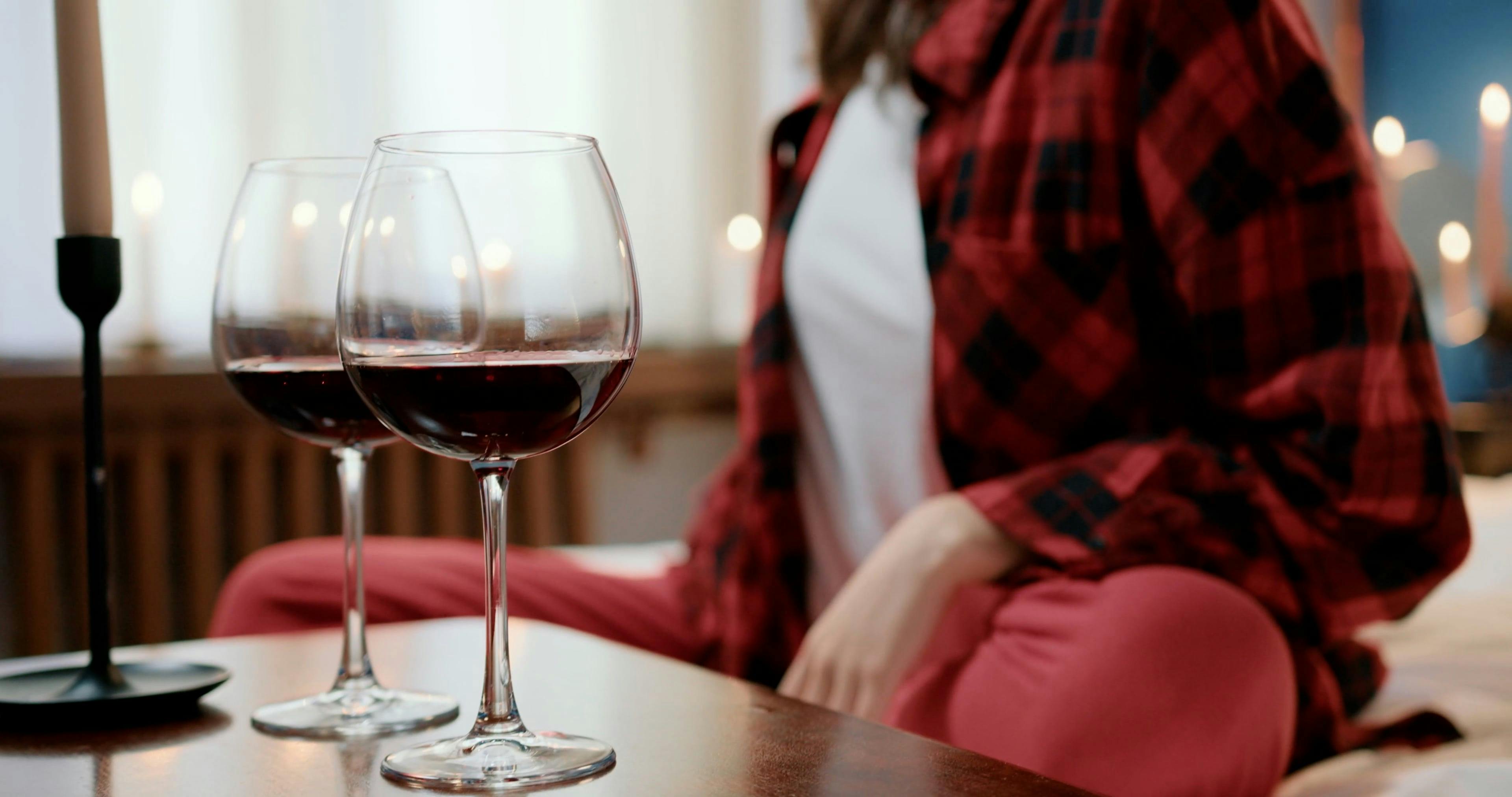 A Woman Eating Chocolate and Drinking Wine while Watching Movie on Her